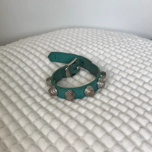 Balenciaga armband - Säljer mitt välanvända Balenciaga armband pga att det ej används. Jättefin turkos färg i storlek S. Kvitto eller dustbag finns tyvärr ej kvar. Det finns slitage på armbandet, men går självklart fortfarande att använda. Köparen betalar frakten.
