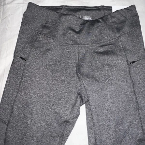 Tränings leggings  - Grå tränings leggings med fickor på sidorna. Aldrig använda med etikett kvar 
