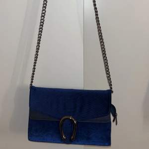 En vanlig blå väska med silver detaljer 