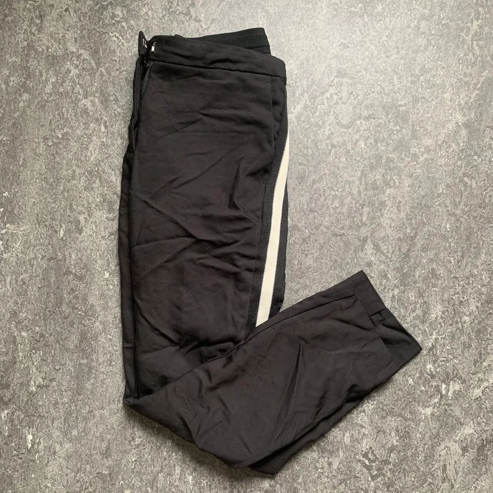 Svarta byxor med vit rand och låg midja från Zara i storlek M. Använda ca 3 gånger. Frakt tillkommer. . Jeans & Byxor.