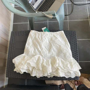Kjol storlek 38 - Kjol ursprungligen frn h&m, aldrig använd med prislapp kvar. Har broderi anglaise. Dragkedja i sidan. Frakt tillkommer, köparen står för frakten. 