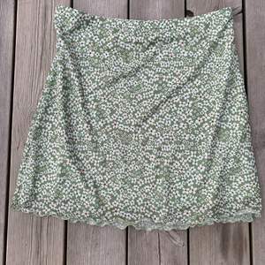 En ljusgrön kjol med vita blommor på.🌸 midjemått: 74 cm. Höftmått: 96 cm. Längd:44,8 cm. Lite stretch🫶🏻. Inga tecken på användning✨ original pris= 69kr men säljer den för 20 + frakt(39kr)😍💗
