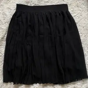 Plisserad svart kjol från Nakd strl L, men skulle säga att den är en M🤍
