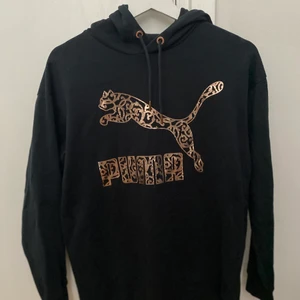 Puma hoodie - Svart Puma hoodie med guld detaljer i bra skick. Storlek 36 men passar även på 38/40