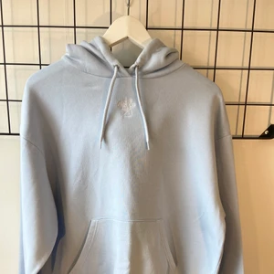 Hoodie Monki - Säljer denna ljusblåa hoodie från Monki! Den har ett litet rivmärken på vänstersidan (tror ni se på första bilden) men det är väldigt litet. Annars är hoodien i jättebra skick!