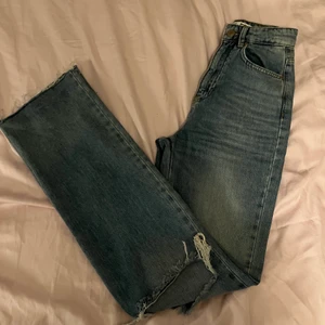 Bootcut jeans - Blåa Bootcut jeans från stradivarius med hål på knäna. Superfina och tighta runt rumpa och lår, men lösa från knäet och ner. Fint skick men knappen hoppar ur ibland. 