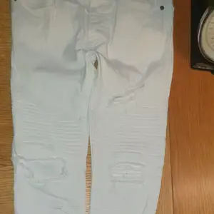 Vita skinny jeans, fint skick dock en liten fläck på bakfickan, se bild 3. Knappgylf. Sydda veck på låren. Gjorda slitningar och hål framtill, hela baktill. 