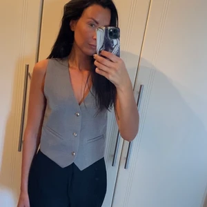 Kostymväst med snygga silver knappar - Grå kostymväst med silver knapppar.   Använd en gång och inga synliga tecken på användning.  Storlek S