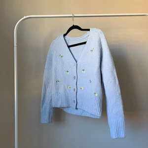 Ljusblå stickad kofta med blommor och snäckskalsknappar - Så söt ljusblå stickad kofta med broderade blommor och snäckskalsknappar! Supersöt på, passar XS-M beroende på hur man vill att den sitter. Nyskick!🦋 Frakt inräknat i priset! 