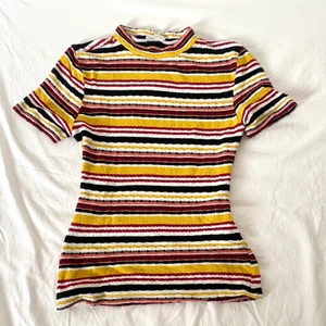 Randig tajt tröja - Randig tröja med en liten turtleneck. Tröjan har höstiga färger och sitter tajt. Den är ganska använd men har inga märken eller hål. Den är även inte nopprig eller urtvättad. Skulle säga att den passar en XS-XXS. 