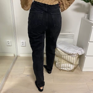 Stentvättade svarta mom jeans - Snygga mom-jeans med resår i midjan vilket gör att den sitter som en smäck! Endast använda ett fåtal gånger, passar S🥰
