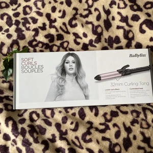 En Babyliss locktång - En locktång som jag knappt har använt jag har väldigt tjock hår då den inte jag komma igenom och gåta lockarna. Den är köpt på Ullared för ca 300kr. Locktången är i en rosa liknande färgmedel svarta detaljer.