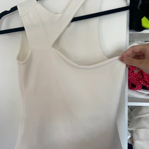 Asymmetrisk topp  - Vit asymmetrisk top från Nelly. Storlek s. Använd fåtal gånger. Frakt ingår i priset 🌸