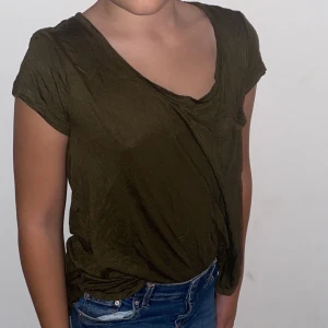 T-shirt - En mörkgrön mjuk t-shirt med liten ficka, gott skick