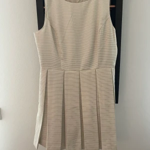 Cocktailklänning från Forever21 - Knälång cocktailklänning med lite guldiga detaljer. Använd en gång. Köparen betalar frakt