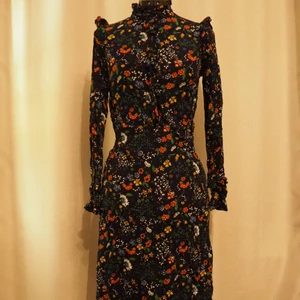 Långärmad bohemisk klänning - Blommig bohemisk klänning i luftig viskos med knäppning upptill. Lite längre än knälång.