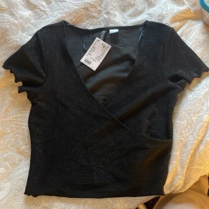 Glittrig topp - Glittrig topp från hm i storlek S. Aldrig använd och prislapp är kvar. Säljer för den ej kommit till användning.