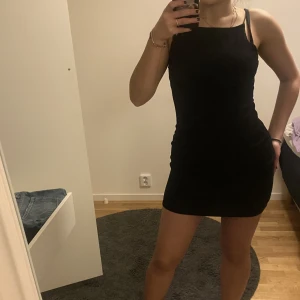 SVART KLÄNNING - Kroppsformande men stretchig svart klänning från Gina Tricot. Den är öppen i ryggen och passar till så många olika tillfällen. Kan användas från skolan till fester. Den är så stretchig att den nog passar både XS,S och M.