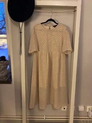 Söt prickig sommarklänning. Löst sittande modell, T-shirt ärmar och tunt skirt tyg nertill. Använd 1 gång, säljer då den inte riktigt var min stil 🥰 beige rosa färg och svarta prickar, Midi längd 