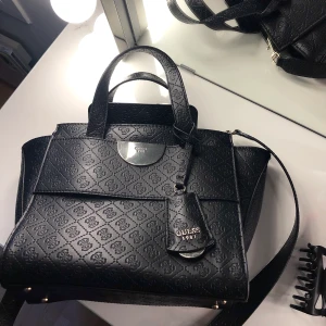 Guess  - Säljer min fina äkta guess väska som inte kommer till användning nå mer, köpt för 2399 på Åhléns förra året, fortfarande jättebra skick och har inga skador🖤
