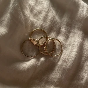 4 ringar - 3 stycken med vita fejk diamants ringar och sen en rosa med fejk diamant ring