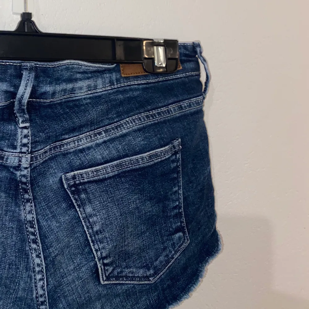 ett par korta, lågmidjade, blåa jeansshorts. Köpte för flera år sedan (finns inte kvar i sortiment) men inte använts alls. Storlek 36, väldigt strethsiga dock. Shorts.