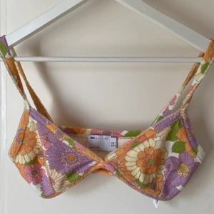 Blommig bralette🌸 - En blommig bralette/topp i frotté köpt på ASOS och aldrig använd. Lite 70-tal stil med blommor i olika färger. Sitter väldigt skönt på och kan även användas som topp! TRYCK INTE PÅ KÖP NU!