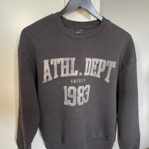 Mörkgrå sweatshirt  - Klicka inte köp nu🤗 Mörkgrå sweatshirt med tryck från Ginatricot. Strl XS men passar även en S. Vet ej nypris, jag säljer för 100kr. Har tyvärr ingen bild med tröjan på. 