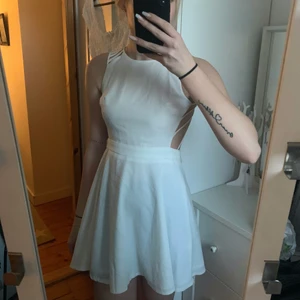 Vit klänning -  En vit klänning som är u-ringad och som går rätt högt upp mot halsen. Öppen rygg bortsätt från stripsen som ni ser på bilden samt att den har dragkedja i ryggen. Denna klänning har jag använt en gång men är fortfarande lika fin som när jag fick hem den. Klänningen har inte jättemycket stretch men är enligt mig ändå väldigt fin o ha på. 🤍 det står ingen storlek i den men skulle gissa på XS 