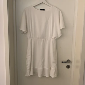 Vit klänning - Säljer denna klänning som jag köpte här på Plick då den tyvärr var för stor för mig som vanligtvis har storlek S! Den är perfekt till tex studenten och den har en superfin liten öppning i ryggen! Klänningen är från märket AX Paris och är i storlek 10 vilket motsvarar storlek 38. Köparen står för frakten🤍
