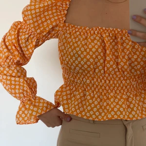 Orange topp  - Topp med puffärmar och åtsittande midja. Aldrig använd. 