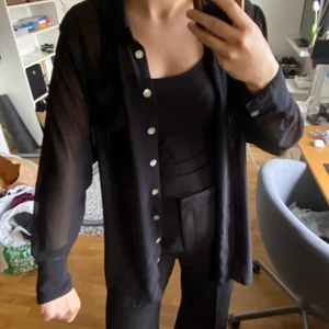 Joy svart mesh-skjorta - En lång skjorta av svart mesh som jag inte lyckats styla och därav inte använt. Säljer för dne förstjänar mer rampljus. Är en M/L 