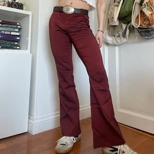 Röda svarta utsvängda byxor 90s 2000s - Röda och svarta skimriga lågmidjade utsvängda byxor med bästa 90s och 2000s viben! 🍒 Så snygga för en utekväll med en skjorta/blus eller för en vardaglig outfit släng på en babytee och ett par sneakers! Skriv för mått :)