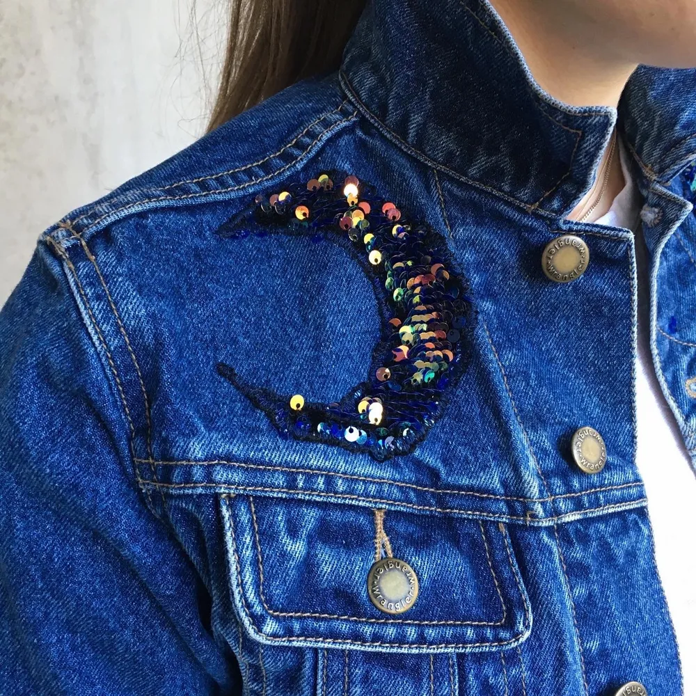 Reworked wrangles sport denim jacket. Flip sequin application in the shape of the sun and the moon and the stars. Also single sequins spread out on the left shoulder.   This jacket is a unique one of a kind find. Super cool and rad looking. You can choose to wear the sequins flipped down for the blue color or up to see the golden color.   Size S, Measurements:  Front length: 40 cm Shoulder: 13 cm Back length: 47 cm Back width: 45 cm Arm length outside: 46 cm Arm length inside: 36 cm. Jackor.