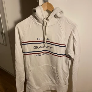 Vit Ganthoodie i strl S - Vit Ganthoodie i gott skick. Storlek S i herrstorlek. Lite använd så den är i bra skick. Vit med mörkblå och röda linjer. 