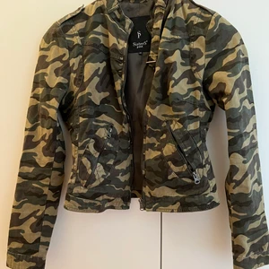 Kamouflagejacka - Jacka i kamouflage. Liten i passformen.