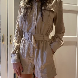 Beige byxdress H&M - Snygg och skön byxdress från H&M. Mycket bra skick. Oanvänd och med prislappen kvar. Storlek 34 men passar även 36. Modellen är runt 166 cm lång.