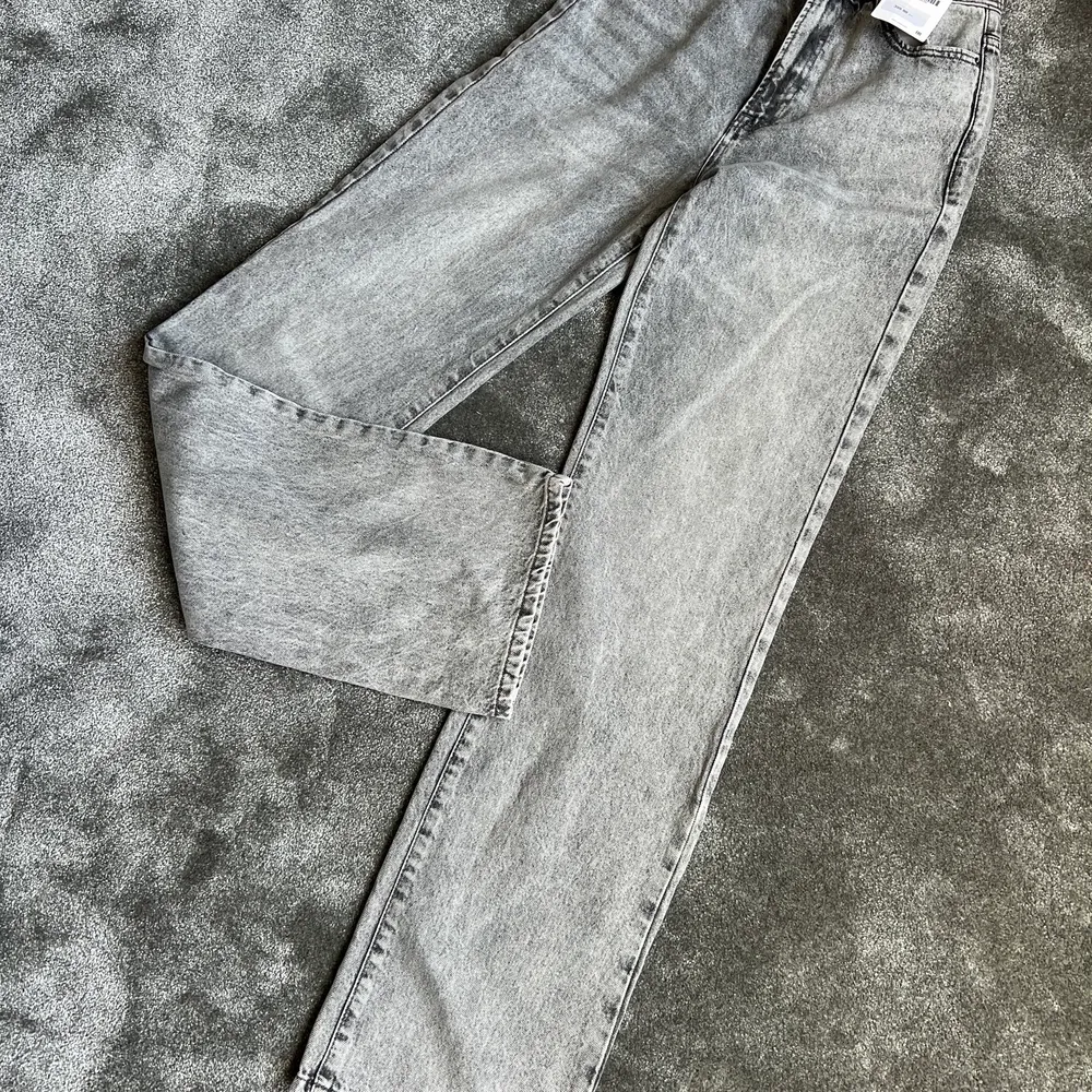 Säljer dessa fina gråa jeansen från Zara, de är i helt nytt skick och aldrig använda, prislappen finns kvar och de är i storlek 34!. Jeans & Byxor.