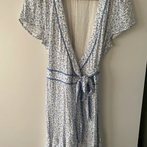 Bikbok mini omlott klänning strl S - Bikbok mini omlott klänning med blåvita blommor. Väldigt fint skick. 