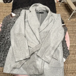 Zara - Jacka med bälte i midjan2 öppna framfickor100% PolyesterLängd: 77 cm i storlek XSModellen bär stol S