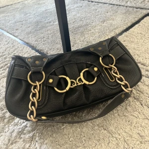 Väska - En snygg och rymlig väska. Finns två större fack inuti ich sedan även ett litet böde inuti och ett på utisdan.