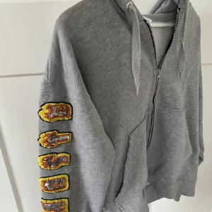 Sandro hoodie - En huvtröja från märket sandro. Super coool och i bra skick förutom färgfläcken på sista bilden (men inget man tänker på) köpt för 1500kr
