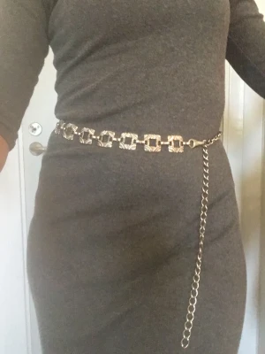 Chain belt - Ett bälte som liknar en kedja i vit metall. 100 cm långt  