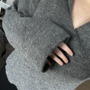 Stickad tröja - Grå stickad tröja med breda armar och ”krage”