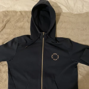 Hugo Boss tracksuit - Fin tracksuit ifrån Hugo boss. Har använts relativt mycket, men är i ok/gott skick.  Mörkblå. Storlek L men ifall man bär storlek M så passar dem. Bara byxorna 500:-. Bara tröjan 800:-. Hela tracksuiten för 1200:-  Priset kan diskuteras!