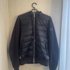 Moncler Cardigan  - Moncler cardigan (black Logo) Size 2 (M) fits S Väldigt fin jacka, bra använd men även inga skador på den.  Bud givning från 3000kr Direktköp på 4000kr  