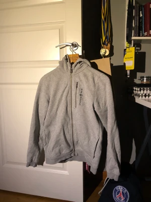 Grå Sail racing zip Hoodie strlk 170  - Fin hoodie som har använts väl men försiktigt. Tyvärr har den blivit förliten därav säljer jag den. Den är i fint skick utöver att den är lite sliten inuti. Strlk 170. Nypris : 1000kr 