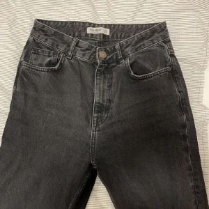 Jeans - Svarta supersnygga jeans i hägmidjad modell från Pull&bear med slit vid fötterna. Sjukt långa ben så lite slitna längst ner men i övrigt super skick.