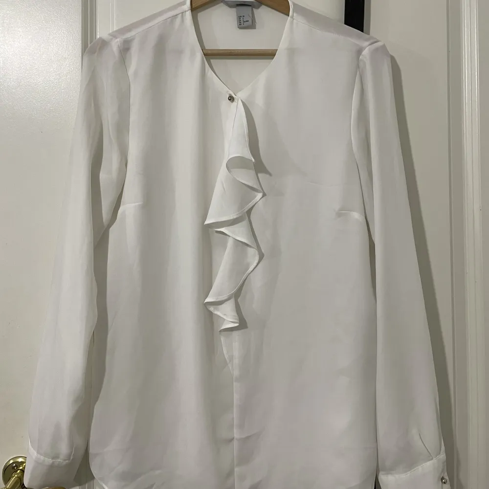 En vit skjorta/blus som är detaljerad på framsidan men lite genomskinlig på baksidan. Dock inte genomskinlig på framsidan. Den är av silk och köpt på hm. Har bytt stil så den funkar inte på mig.. Blusar.