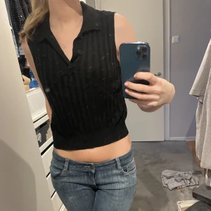 Svart topp - Svart topp med krage och knappar. Knappt använd 